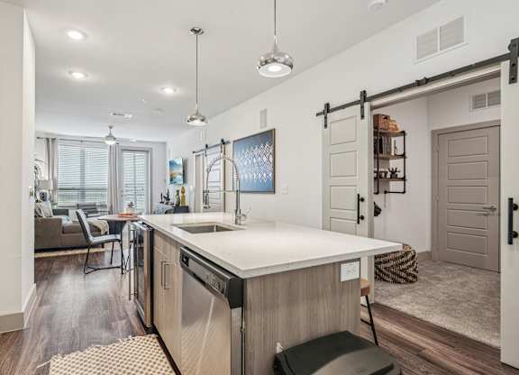 A modern kitchen with a large island and pendant lights.