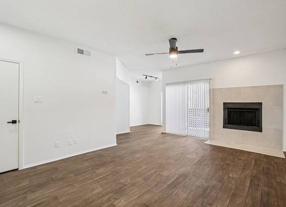 A room with a fireplace and a ceiling fan.