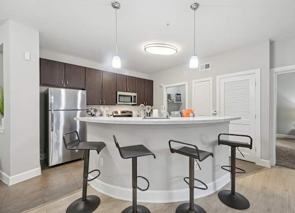 A kitchen with a bar and stools.