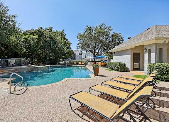 A pool with a slide and sun loungers.