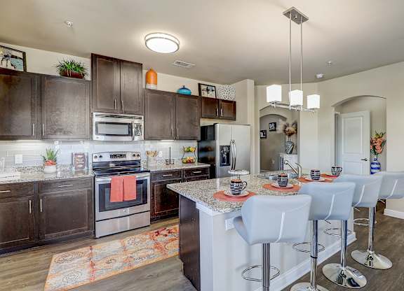 a kitchen with stainless steel appliances and a table with chairs