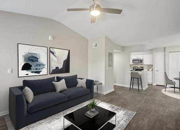 A living room with a dark blue couch and a coffee table in the center.
