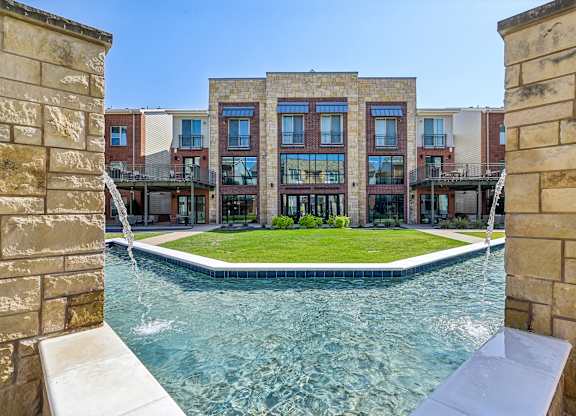 A swimming pool is surrounded by a stone wall.