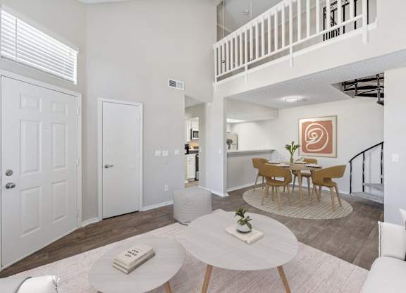 a living room with a dining room and a staircase