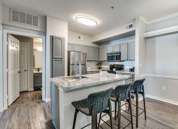 a kitchen with a large island with bar stools