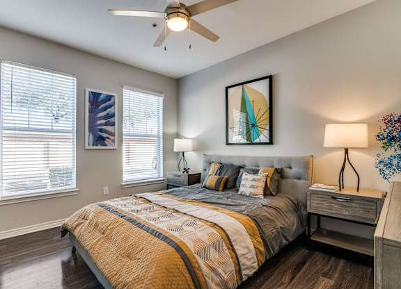 a bedroom with a large bed and a ceiling fan