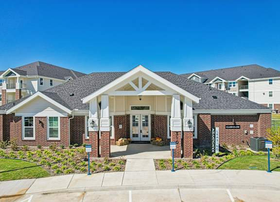 A large building with a white entrance and a sign that says "Welcome" in front of it.