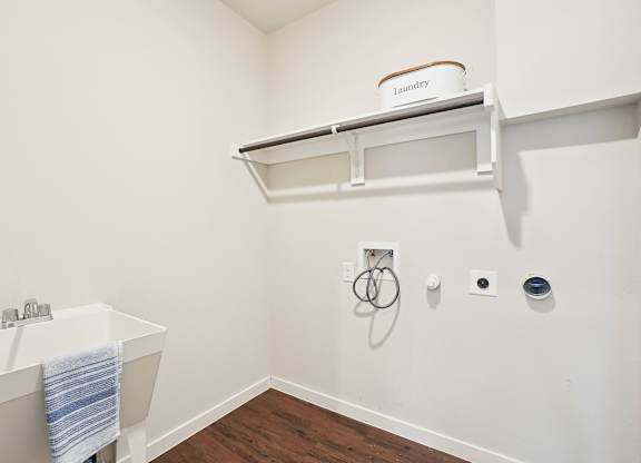 A white bathroom with a white tub and a white shelf.