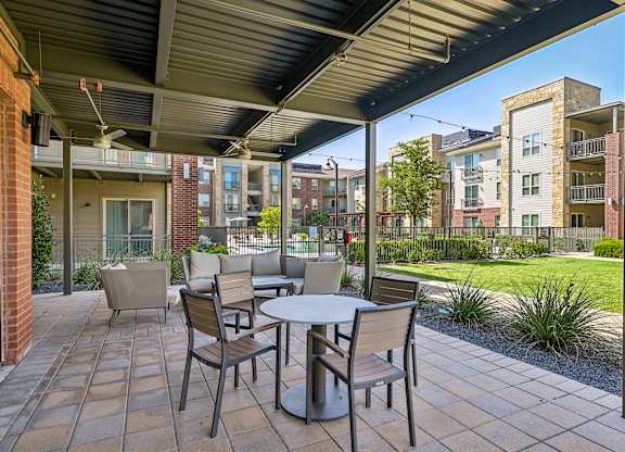 A patio with a table and chairs is set up outside a building.