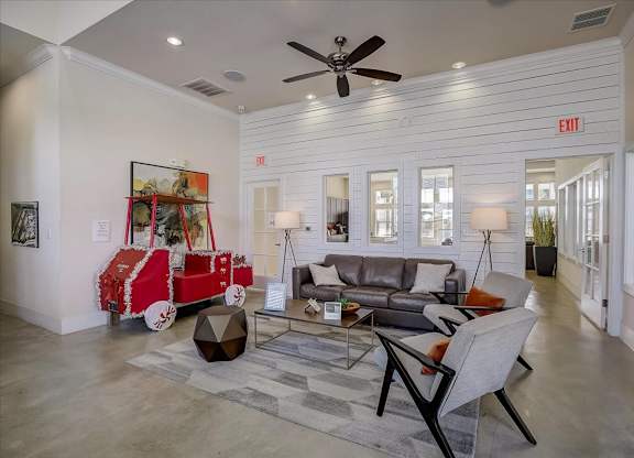 Clubhouse living area with sofa seating, area rug, and bright open layout.