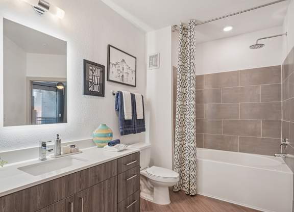 A bathroom with a white sink, toilet, and bathtub.