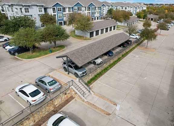 an aerial view of a parking lot and a building with cars parked
