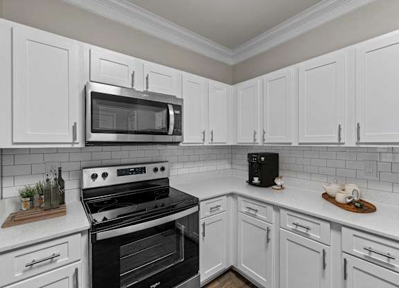 a kitchen with white cabinets and black appliances and a microwave