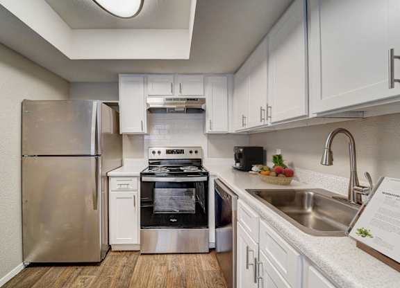 a kitchen with stainless steel appliances and white cabinets