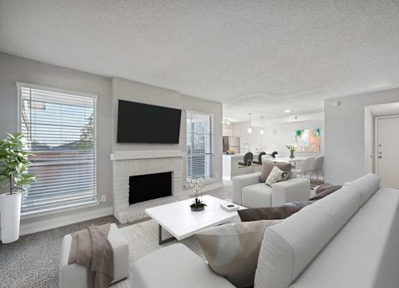 a living room with white couches and chairs and a fireplace