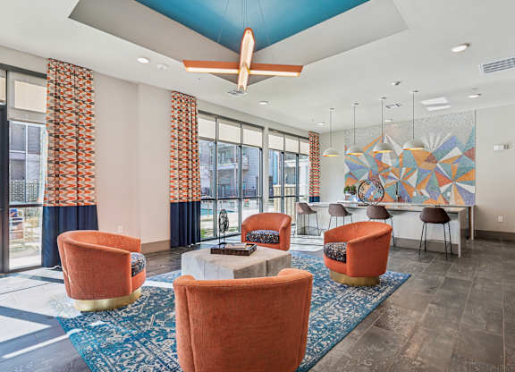 A room with orange chairs and a ceiling fan.