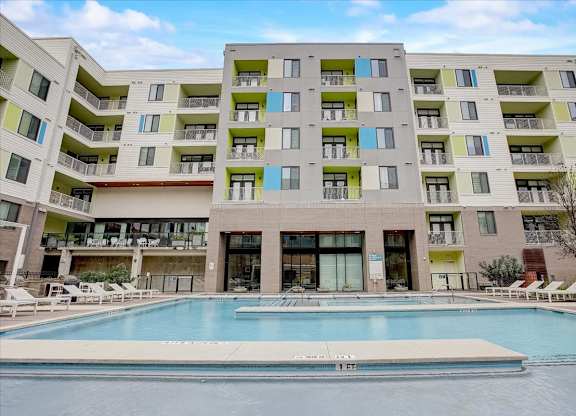 Resort-style courtyard pool with central walkway and apartment balconies above.