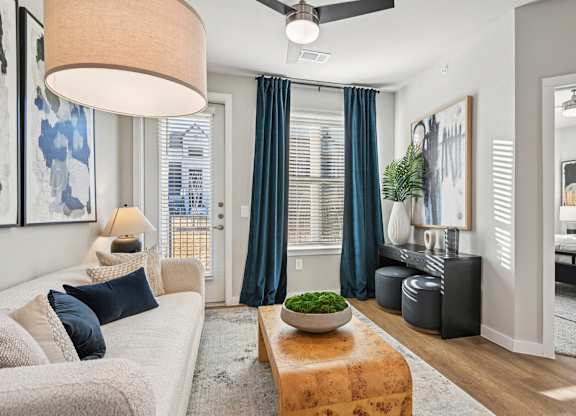 A modern living room with a large window and a ceiling fan.