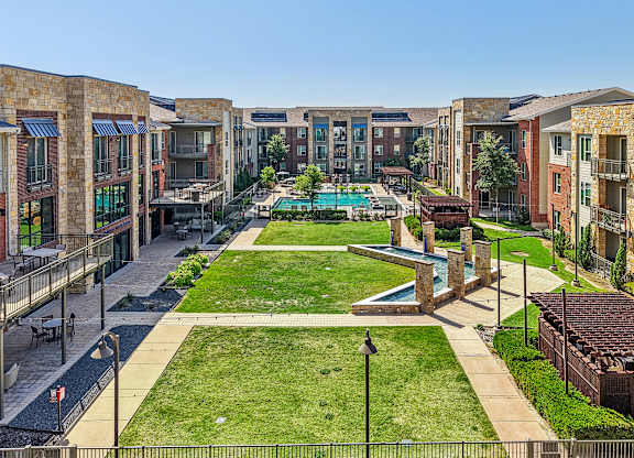 A view of a courtyard with a pool and a fence.
