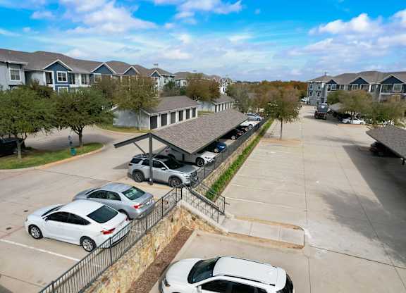 a parking lot with cars parked in front of houses