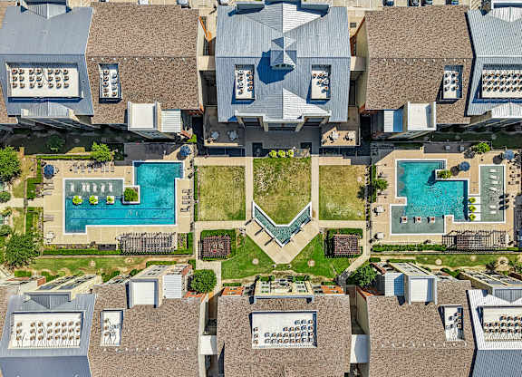 A bird's eye view of a residential area with houses and swimming pools.
