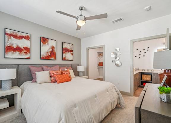 A bedroom with a large bed and a ceiling fan.