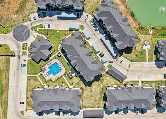 A bird's eye view of a residential area with houses and a swimming pool.