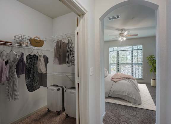 a bedroom with a closet and a bed and a ceiling fan