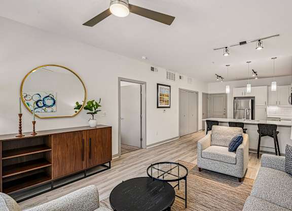 A living room with a grey couch, a black coffee table, and a wooden cabinet.