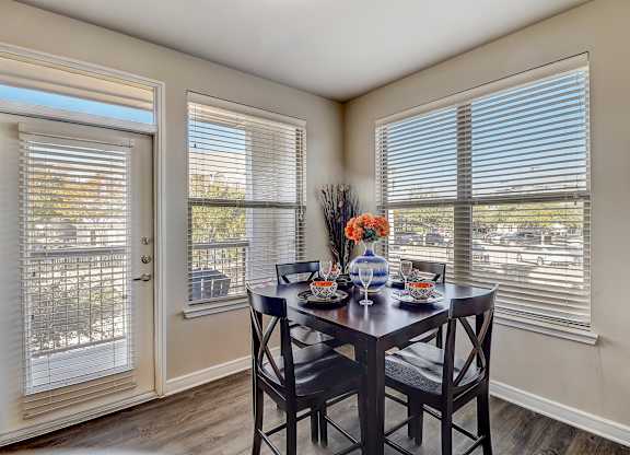 a dining room with two windows and a table with chairs
