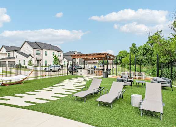 A sunny day at a park with lawn chairs and a white patterned walkway.