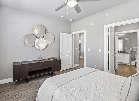 A bedroom with a large bed and a wooden dresser.