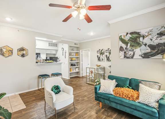 A living room with a green couch and a white chair.