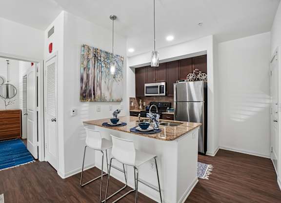 A kitchen with white cabinets and a wooden island.