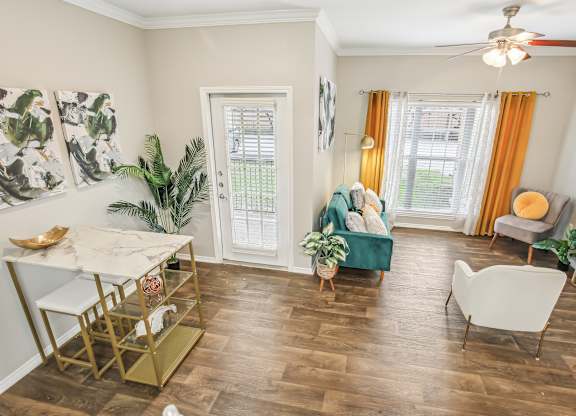 A living room with a green couch and a white chair.