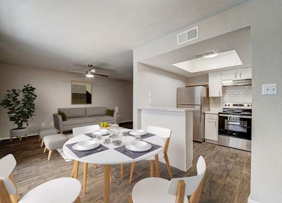 a living room and dining room with a white table and chairs