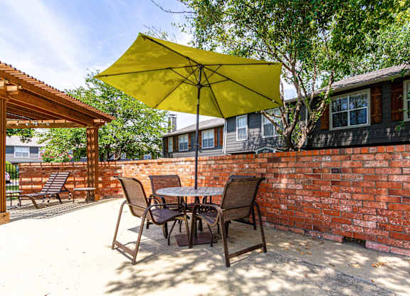 a patio with a table and chairs and an umbrella