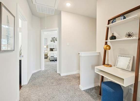 A hallway with a white cabinet and a shelf with a picture frame on it.