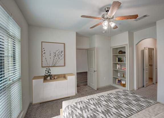 a bedroom with a bed and a ceiling fan