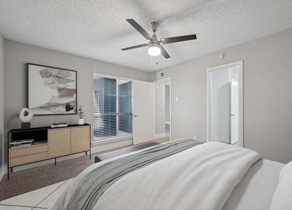 a bedroom with a large bed and a ceiling fan