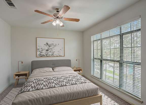 a bedroom with a bed and a ceiling fan