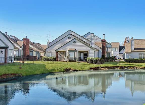 A row of houses with a pond in front.
