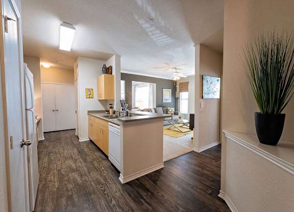 A kitchen with a refrigerator, sink, and cabinets.
