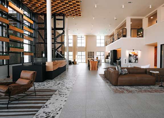 a large living room with couches and chairs and a staircase