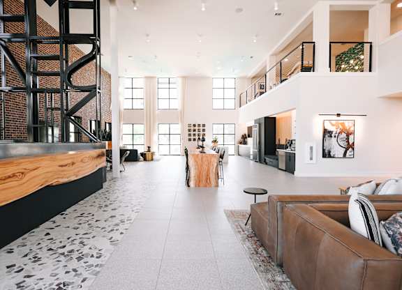 a large living room with a fireplace and a staircase in the middle