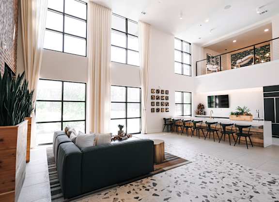 a living room with a black couch and a table with chairs