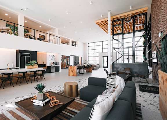 a living room with a black couch and a table with chairs