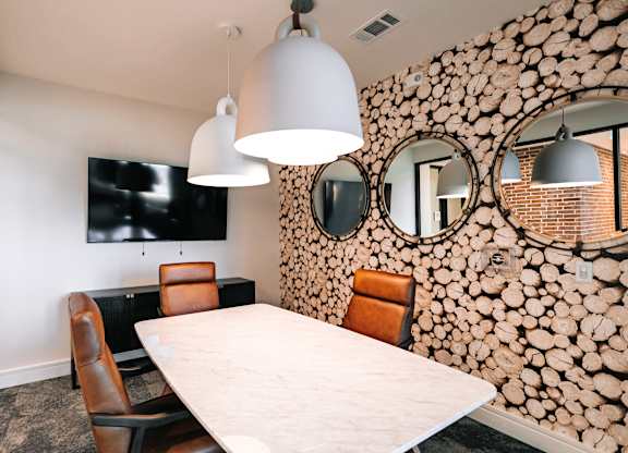 a dining room with a table and chairs and a wall of logs