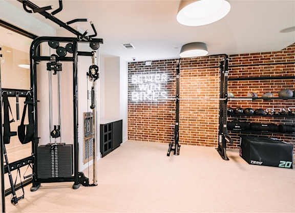 a home gym with a brick wall and exercise equipment