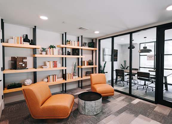 a living room with orange chairs and a table